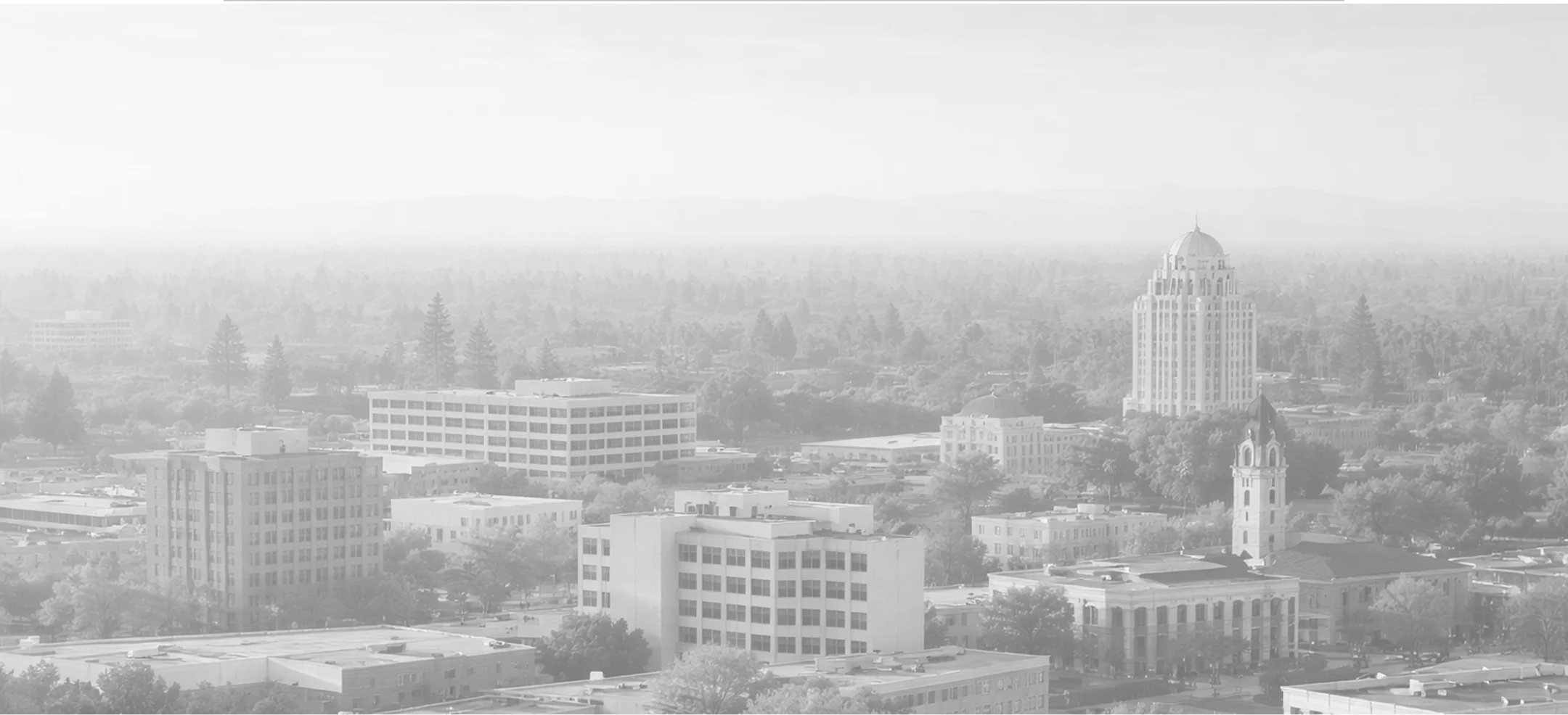Black and white aerial cityscape featuring mid-rise buildings and a domed tower.