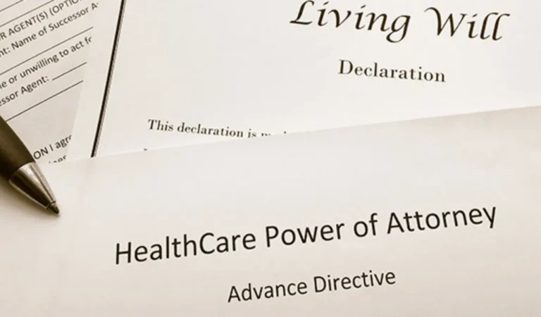 Close-up of legal documents titled "Living Will Declaration" and "HealthCare Power of Attorney Advance Directive" with a pen.