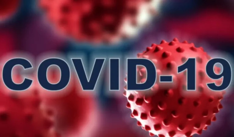 Close-up illustration of red COVID-19 virus particles with bold "COVID-19" text overlay.